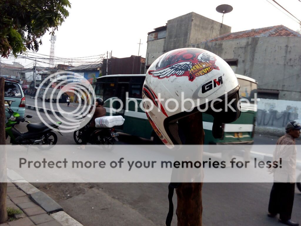 helm tertancap pada ujung tonggak kayu, seperti menjemur kepala atau tengkorak